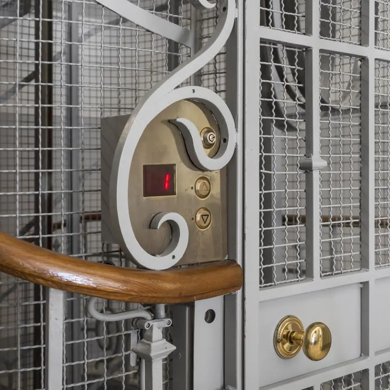 República 23 — wrought-iron cage lift, brass control detail